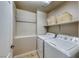 Clean laundry room with full-size washer and dryer, shelving, and neutral walls at 193 Glenbrook Estates Dr, Las Vegas, NV 89183