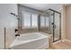 Bathroom featuring a soaking tub, a tiled shower with a glass enclosure, and a window with shutters at 193 Glenbrook Estates Dr, Las Vegas, NV 89183