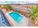 Aerial view of modern pool surrounded by desert landscaping, lush palm trees, and mountain views at 193 Glenbrook Estates Dr, Las Vegas, NV 89183
