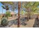 Generous backyard with firepit, desert landscaping, and covered patio with outdoor seating at 2099 Desert Woods Dr, Henderson, NV 89012