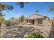 Large backyard with gravel, firepit, desert landscaping, and covered patio seating area at 2099 Desert Woods Dr, Henderson, NV 89012
