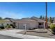 Attractive desert home with a two-car garage, xeriscaping, and rock accents at 2099 Desert Woods Dr, Henderson, NV 89012