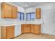 Corner view of the kitchen area showcasing wooden cabinets, white countertops, and tile flooring at 2099 Desert Woods Dr, Henderson, NV 89012