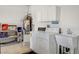 Well-lit laundry room with washing machine and dryer, sink and white cabinets at 2099 Desert Woods Dr, Henderson, NV 89012