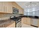 A spacious kitchen featuring granite countertops, stainless steel appliances, and sleek cabinetry at 210 E Flamingo Rd # 105, Las Vegas, NV 89169