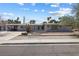 Charming single-story home showcasing xeriscaping, palm trees and a turquoise front door at 2205 Sombrero Dr, Las Vegas, NV 89169