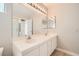 Bathroom featuring double sinks, large mirror with vanity lights, and a shower with glass doors at 239 Eugene Way, Henderson, NV 89015