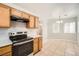Bright kitchen boasts wooden cabinets, stainless steel appliances, and an adjacent dining area with natural light at 239 Eugene Way, Henderson, NV 89015