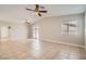 Open living room with tile floors, neutral paint, backyard access, and dual ceiling fans at 239 Eugene Way, Henderson, NV 89015