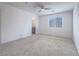 Bright, carpeted main bedroom featuring a ceiling fan and a large window at 2843 Kona Blue Ln # 4, Las Vegas, NV 89183
