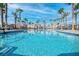 Community pool with palm trees and lounge chairs at 2843 Kona Blue Ln # 4, Las Vegas, NV 89183