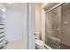 Bathroom including tiled shower with glass doors, and a walk-in closet with custom shelving for storage and organization at 3125 N Buffalo Dr # 1133, Las Vegas, NV 89128