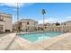Community pool surrounded by palm trees, lounge chairs, and well-maintained condo buildings at 3125 N Buffalo Dr # 1133, Las Vegas, NV 89128