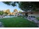 Spacious backyard with a lush lawn, sparkling pool, and covered patio at 3200 Bryant Ave, Las Vegas, NV 89102