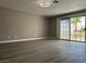 Empty bedroom with updated laminate flooring, neutral paint, and sliding glass door at 3340 Shallow Pond Dr, Las Vegas, NV 89117