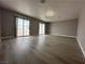 This spacious living room includes wood flooring, a ceiling fan, and sliding glass doors at 3340 Shallow Pond Dr, Las Vegas, NV 89117