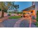 Lush backyard featuring a covered patio, manicured lawn, gravel pathway, and mature trees at 4651 Munich Ct, Las Vegas, NV 89147