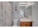 Bright bathroom with a vanity featuring a wood cabinet, white countertop, and decorative floral accents at 4651 Munich Ct, Las Vegas, NV 89147