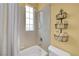 Bright bathroom features a shower-tub combo, neutral tiling, and decorative shelving at 4651 Munich Ct, Las Vegas, NV 89147
