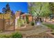 Gorgeous landscaping surrounds this home with a gated entrance to the backyard, including stone pathways and mature trees at 4651 Munich Ct, Las Vegas, NV 89147