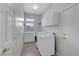 Functional laundry room with a washer, dryer, utility sink, window, and ample storage cabinets at 4651 Munich Ct, Las Vegas, NV 89147