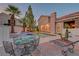 Charming poolside dining area with views of a sparkling pool and lush tropical landscaping at dusk at 4651 Munich Ct, Las Vegas, NV 89147