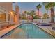 A serene backyard pool area with a spa, surrounded by lush landscaping and bathed in warm sunlight at 4651 Munich Ct, Las Vegas, NV 89147