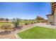 Backyard featuring artificial grass, rock landscaping, and golf course views at 4820 Se Clifftop Dr, Pahrump, NV 89061
