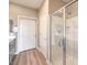 Bright bathroom featuring a glass shower, double doors, gray vanity, and wood look flooring at 4820 Se Clifftop Dr, Pahrump, NV 89061