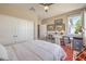 Bedroom with a ceiling fan, natural light, desk, and sliding door closet at 4820 Se Clifftop Dr, Pahrump, NV 89061