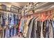Walk-in closet featuring double shelving, hanging clothes, and plastic storage containers at 4820 Se Clifftop Dr, Pahrump, NV 89061