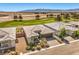 Inviting single-story home boasting desert landscaping and a tile roof, complemented by a lush green golf course backdrop at 4820 Se Clifftop Dr, Pahrump, NV 89061