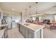 Open-concept kitchen overlooking a living area, featuring an island with stainless steel appliances and a seamless flow at 4820 Se Clifftop Dr, Pahrump, NV 89061