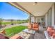 Covered patio with outdoor seating overlooking a manicured lawn, the lush green golf course, and mountain views at 4820 Se Clifftop Dr, Pahrump, NV 89061