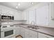 Updated kitchen features a gas range, microwave, and double basin sink under a bright window at 51 Belle Point Ave, Las Vegas, NV 89123