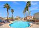 Community pool featuring sparkling blue water, palm trees, lounge chairs, and neighborhood views at 51 Belle Point Ave, Las Vegas, NV 89123