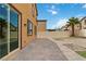 An open backyard features a brick patio area and a privacy fence with palm trees at 5317 Golden Melody Ln, North Las Vegas, NV 89081