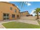 A fenced backyard with artificial turf, brick patio, and palm tree, perfect for entertaining at 5317 Golden Melody Ln, North Las Vegas, NV 89081