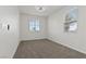 A bright bedroom with neutral carpet, a modern ceiling fan, and natural light from two windows at 5317 Golden Melody Ln, North Las Vegas, NV 89081