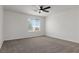 Neutral carpeted bedroom with fan and a window with blinds offering neighborhood views at 5317 Golden Melody Ln, North Las Vegas, NV 89081