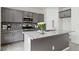 Modern kitchen island featuring gray cabinetry, granite countertops, and stainless steel appliances at 5317 Golden Melody Ln, North Las Vegas, NV 89081