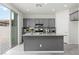Charming kitchen island with seating and gray cabinets, connecting to a bright outdoor space at 5317 Golden Melody Ln, North Las Vegas, NV 89081