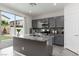 Stylish kitchen island with a sink, gray cabinets, and views of the backyard through sliding glass doors at 5317 Golden Melody Ln, North Las Vegas, NV 89081