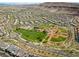 Overhead community view with baseball field, park, playground, and surrounding homes with mountains visible at 5594 Trilling Bird Dr, Las Vegas, NV 89135