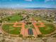 Wide view showcasing community park with baseball field, tennis courts, playground, and well-kept landscaping at 5594 Trilling Bird Dr, Las Vegas, NV 89135