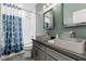 Bright bathroom with double sinks, gray vanity, and a shower-tub combo with a stylish curtain at 5594 Trilling Bird Dr, Las Vegas, NV 89135