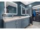 Bathroom featuring double sinks, backlit mirrors, and an entrance to the walk-in closet at 5594 Trilling Bird Dr, Las Vegas, NV 89135