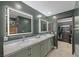 Bathroom featuring dual sinks with marble countertops and illuminated mirrors at 5594 Trilling Bird Dr, Las Vegas, NV 89135