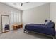 Clean bedroom with neutral walls, shuttered window, gray carpet and a blue bed with decorative pillows at 5594 Trilling Bird Dr, Las Vegas, NV 89135