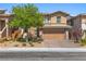 Inviting two-story home featuring a well-kept front yard with stone accents and a two-car garage at 5594 Trilling Bird Dr, Las Vegas, NV 89135